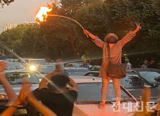 이란 여학생이 히잡을 불태우고 있다.