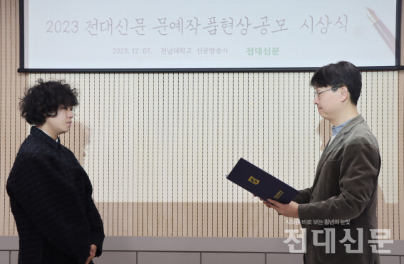 김균수 신문방송사 주간 교수가 시 부문 당선자인 이성록씨에게 상장을 수여하고 있다.