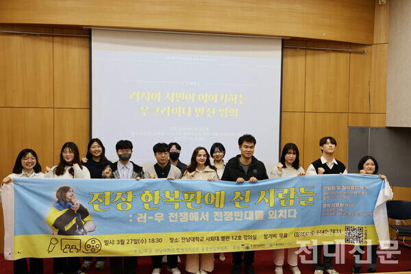 간담회가 끝난 후 알렉산드라씨와 간담회 참여자, 용봉교지 위원들이 모여 플래카드를 들고 기념사진을 찍고 있다.