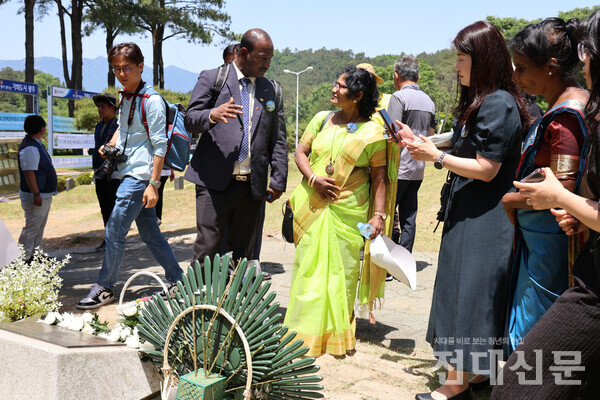 수간티니 인권활동가와 함께 5·18민주묘지를 찾은 아난티 새시테란 인권활동가가 위르겐 힌츠페터의 묘지 앞에서 설명을 듣고 있다.