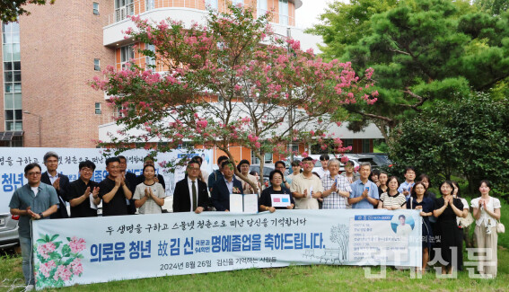 고(故) 김신 동문의 명예 졸업식 참석자들이 배롱나무 앞에서 단체 사진을 찍고 있다.