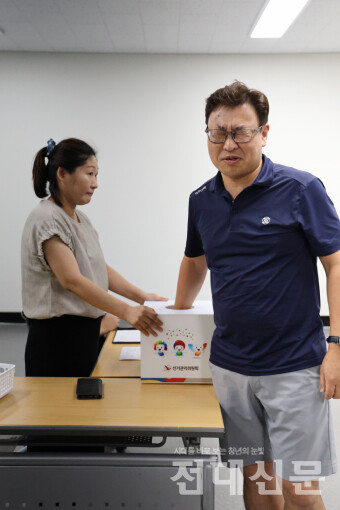 두 눈 질끈 감고! 총장 후보자 기호 추첨은 지난 10일 북구선거관리위원회에서 진행됐다. 사진은 기호 2번 후보자 대리인이 기호를 추첨하는 모습