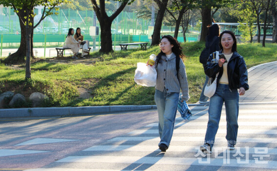 우리 대학 학생들이 용지 앞 도로를 건너고 있다.