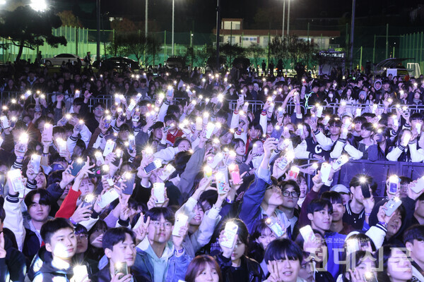 휴대폰 플래시를 흔들며 무대에 호응하고 있는 학생들의 모습이다.