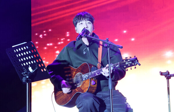 가수 로이킴이 기타 연주와 함께 노래를 부르며 무대를 채우는 모습.