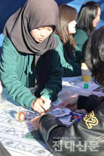 국제교류행사 부스에서 참가자에게 스탬프를 찍어주는 모습.