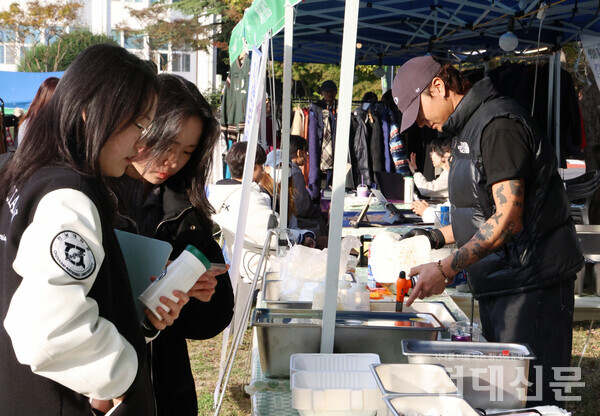 봉지에 위치한 '깁미버거 본투비 타코' 음식 부스를 구경하고 있는 학생들의 모습.