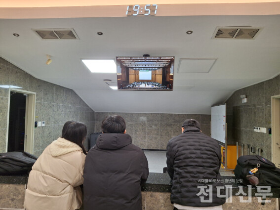 민주마루홀 외부에서 모니터로 학총 현장을 확인하는 학생들의 모습.