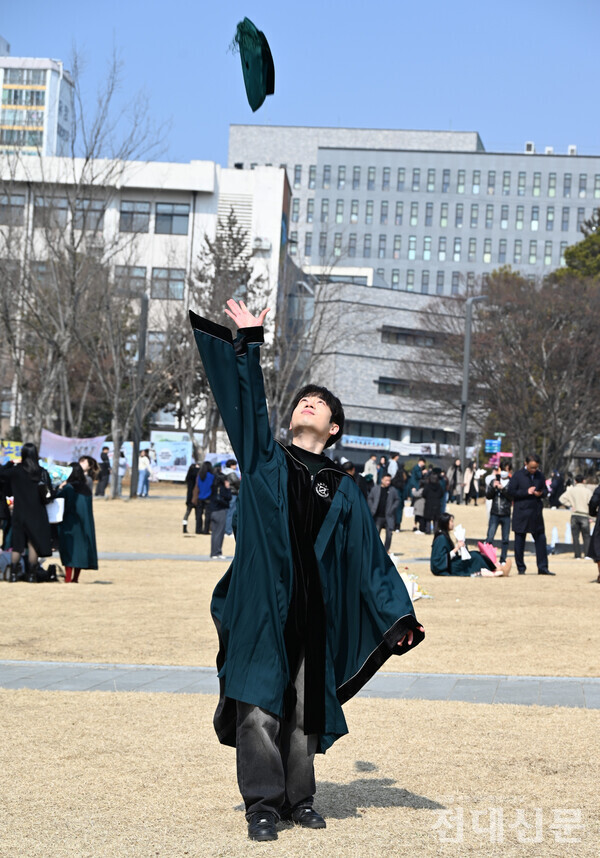 한 졸업생이 5ㆍ18광장(봉지)에서 학사모를 하늘 높이 던지고 있다.