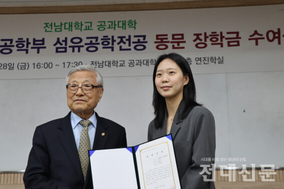 동문 김해곤 박사가 장학금을 학생에게 전달하는 모습이다.