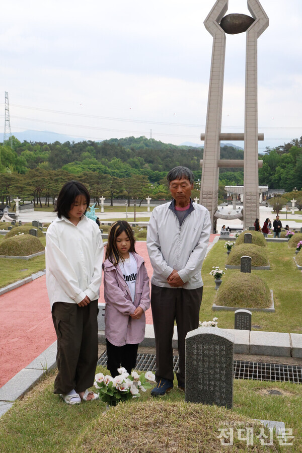고동석(77)씨와 그의 손녀들이 지난 6일 국립5·18민주묘지 제1묘역에서 유공자를 추모하고 있다. 경남 거창에서 가족들과 여행 온 고씨는 “가족들과 5·18민중항쟁의 역사적 의미를 느끼고자 묘지에 방문했다”고 말했다.