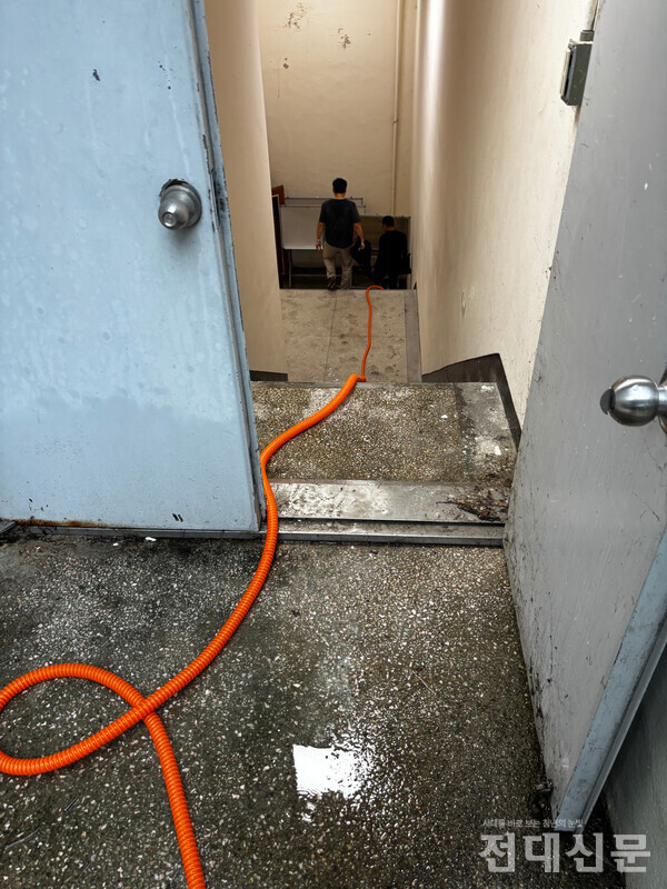 백도 지하 1층에 찬 빗물을 배수펌프와 호스를 이용해 빼내고 있는 모습. 당시 현장에 있던 교직원은 지하 1층 출입을 통제하며 