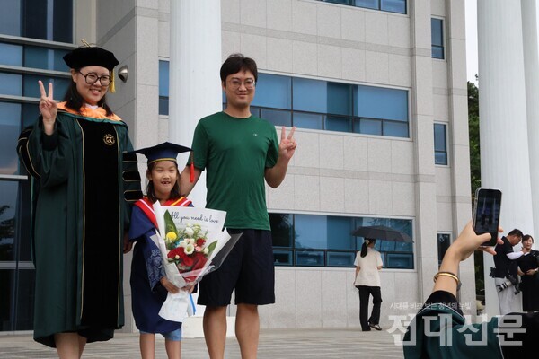 가족과 함께 학위복을 맞춰 입고 졸업 사진을 찍고 있다. 지난 26일 급작스런 소나기에 날씨는 흐렸지만 졸업생의 미소는 화창하다. 