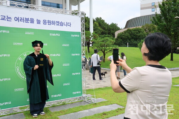 민주마루 앞에 마련된 포토존에서 사진을 찍고 있는 이경건(수산생명의학·21)씨. 그는 “졸업해서 후련하다”고 말했다.
