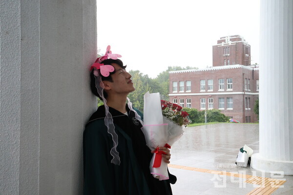 송우성(행정·19)씨가 민주마루에서 포즈를 취하고 있다. 그는 졸업소감으로 “또 취업이라는 전쟁이 벌어질 걸 알고 있지만, 현재를 즐기자는 마음으로 임하겠다”고 말했다.