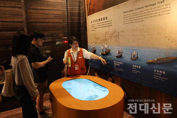 가이드 천취안취안씨와 함께 문화창의산업단지를 둘러보는 모습. 취안취안씨가 신문방송사 기자들에게 문화단지에서 보존하고 있는 심해 유산에 대해 설명하고 있다.