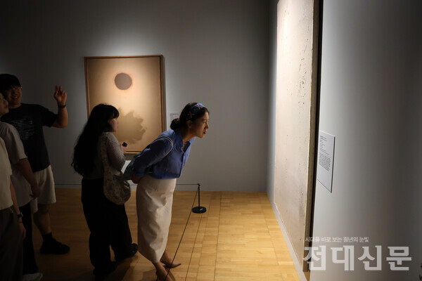 지난달 22일 관람객들이 전시회에서 작품을 감상하고 있다.