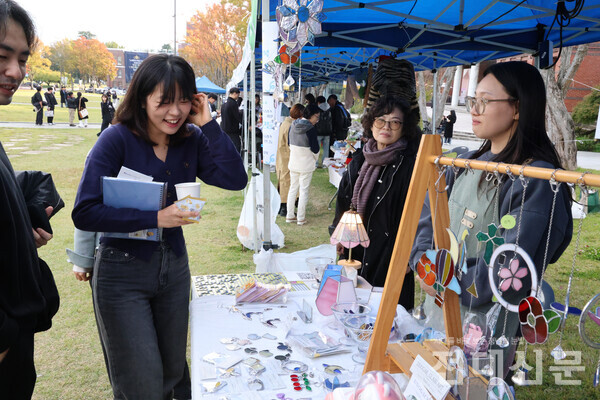 2024년 용봉대동풀이에서 한 학생이 썬캐처를 파는 부스를 구경 중이다.