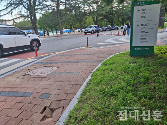 대학본부 표지판 앞에 위치한 부식 맨홀. 맨홀 근처 땅이 움푹 패여있다.
