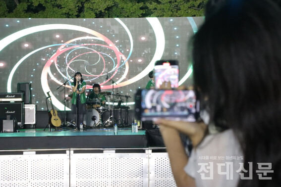 학생들이 무대에서 공연하는 유다빈 밴드를 촬영 중이다.