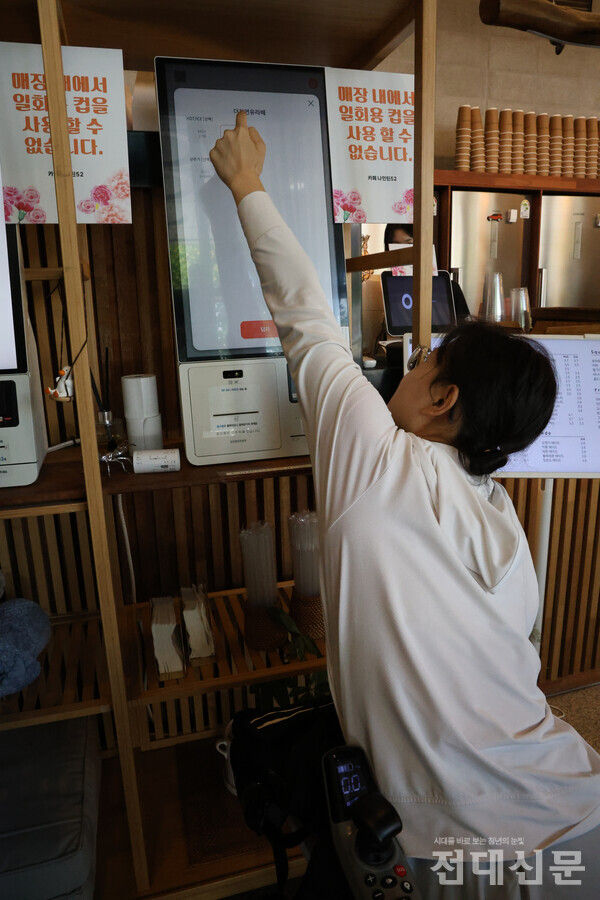 김규리(국어국문·25)씨가 휠체어를 타고 카페 키오스크를 이용하고 있다.