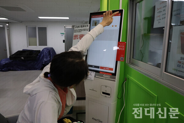 키오스크 ‘X’ 버튼을 누르기 위해 손을 뻗는 김규리씨.