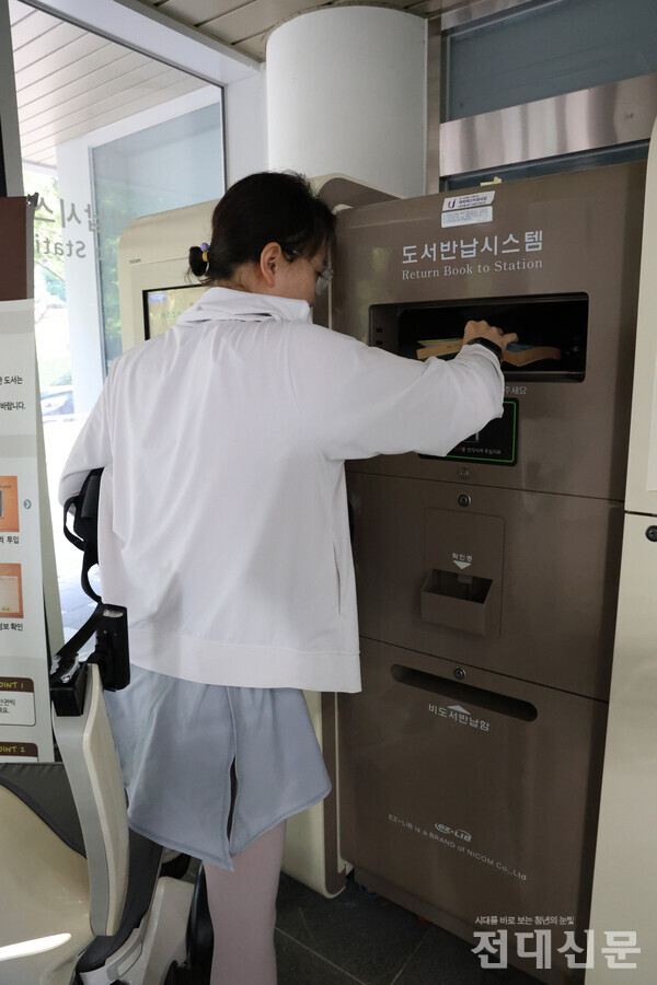 김규리씨가 무인 책반납을 하기 위해 휠체어에서 일어나는 모습.