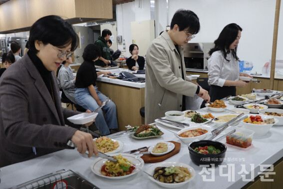 심사 위원이 음식을 시식하며 평가하고 있다.