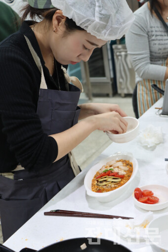 참가자가 '토마토 현미 리조또'의 가니쉬 작업을 하고 있다.